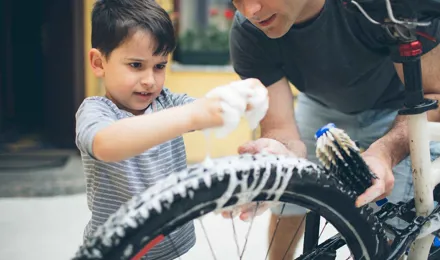 Tatăl și fiul curăță o bicicletă