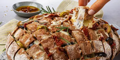 Mediterranes Zupfbrot Rezept: Mit getrockneten Tomaten und leckerem Olivenöl ein Highlight auf jedem Tisch.