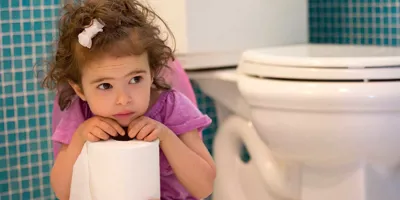 Ένα κορίτσι κάθεται στο γιογιό κρατώντας ένα ρολό χαρτί τουαλέτας στα χέρια της