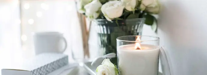 Eine handgemachte Kerze und Strauß Rosen auf einem Tisch