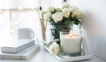 Eine handgemachte Kerze und Strauß Rosen auf einem Tisch
