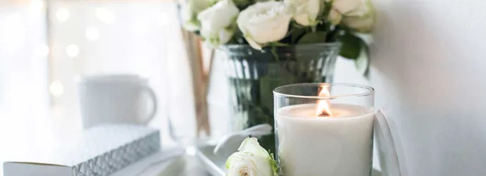 Eine handgemachte Kerze und Strauß Rosen auf einem Tisch