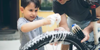 Отец и сын чистят велосипед