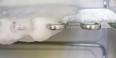 Közeli kép egy hűtőrácsról, amiről a jég már félig leolvadt.