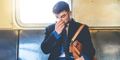 Един човек, облечен в костюм седеше на превоз с влак изсекна