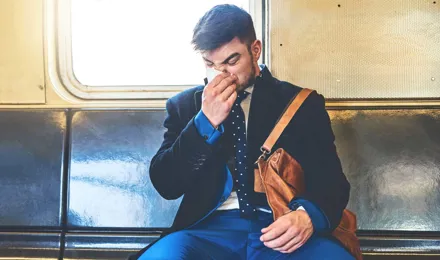 Един човек, облечен в костюм седеше на превоз с влак изсекна
