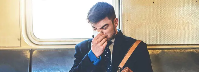 Един човек, облечен в костюм седеше на превоз с влак изсекна