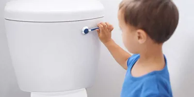 Malý kluk splachuje toaletu