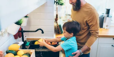 Maminka pomáhá v kuchyni dětem umýt si ruce