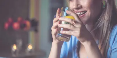 Žena se sklenicí vody s plátkem citronu