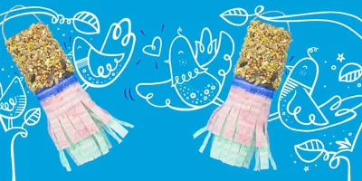 Ručno izrađene hranilice za ptice sa sjemenkama i ukrasnim papirnatim resama koje vise s ilustriranih grana s ilustriranim pticama