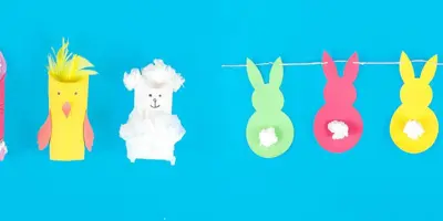 Ein Hase, ein Küken und ein Lamm aus dekorierten Toilettenpapierrollen fürs Osterbasteln