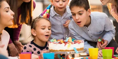 Діти стоять навколо торта на вечірці з нагоди дня народження