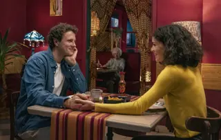 Ein Mann Und Eine Frau Sitzen An Einem Tisch In Einem Restaurant, Halten Sich An Den Händen Und Lächeln Sich An
