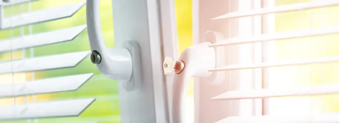 Ein leicht geöffnetes Fenster mit schräg gestellten Jalousien lässt Tageslicht ins Zimmer fallen.