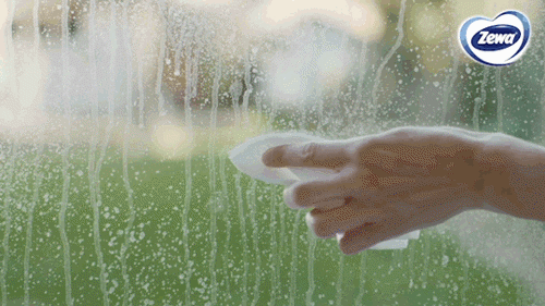 Un GIF cu o mână care curăță cu o cârpă un geam cu pete.
