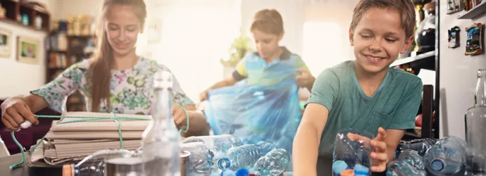 Gyerekek válogatják a műanyag palackokat az otthoni újrahasznosításhoz.
