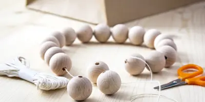 Jednoduchý držák kuchyňských utěrek z dřevěných korálků